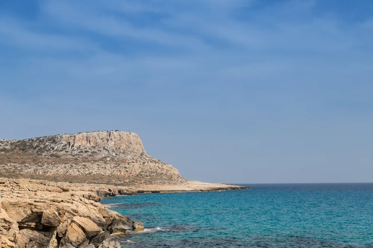 A rocky headland with pale cliffs above a turquoise bay